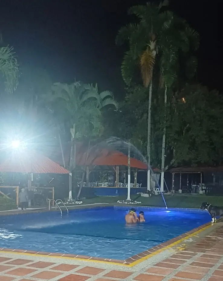 Huéspedes nadando en la piscina por la noche